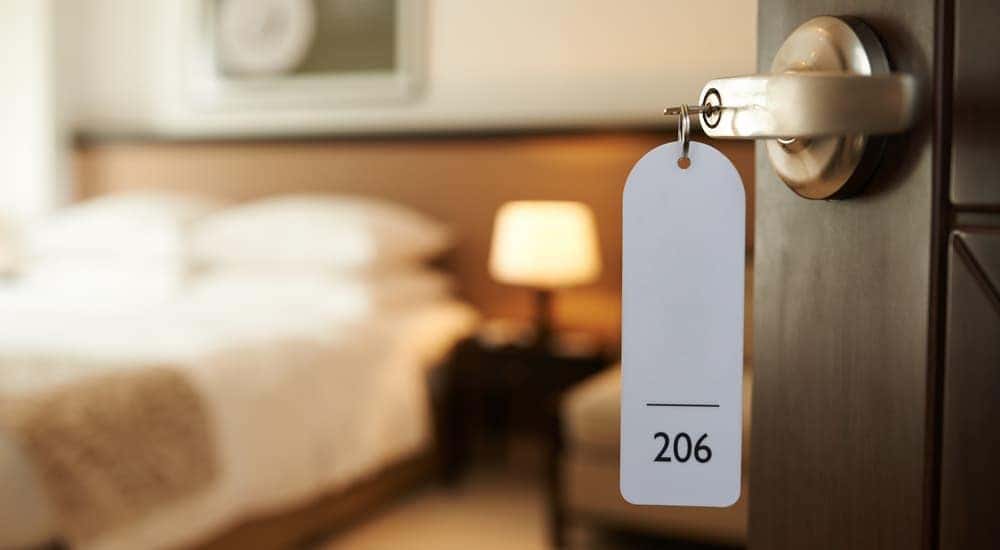 A hotel key numbered 206 is in the door of an open hotel room.