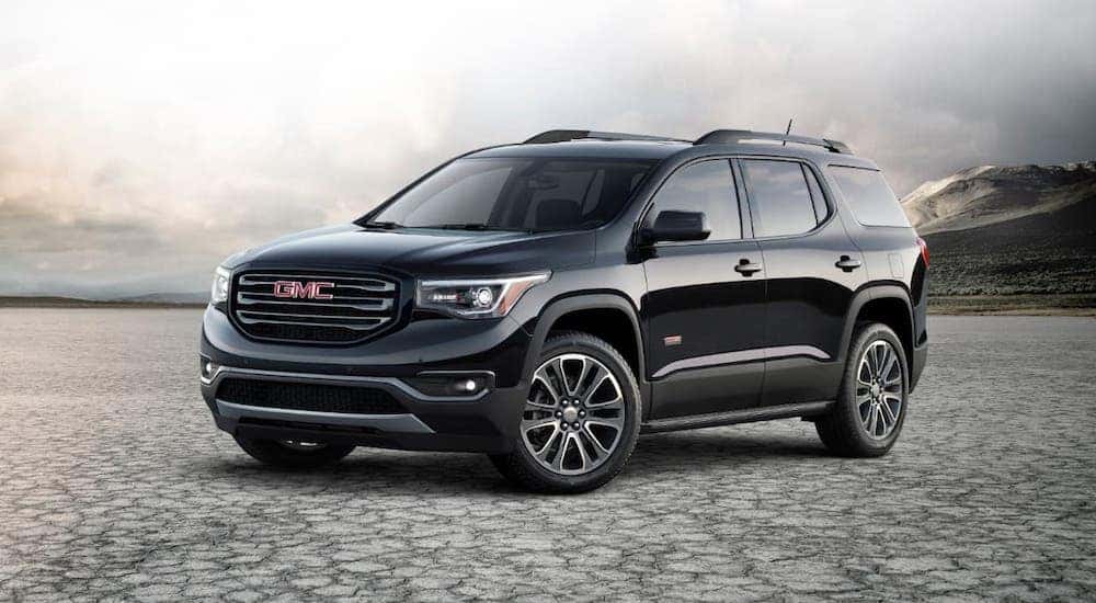 A black 2018 GMC Acadia All Terrain is parked on a misty salt flat.
