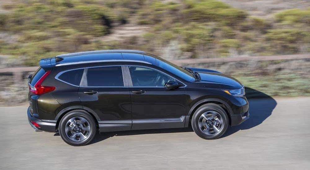 A black 2017 Honda CR-V is shown from the side driving on a road near Atlanta, GA.