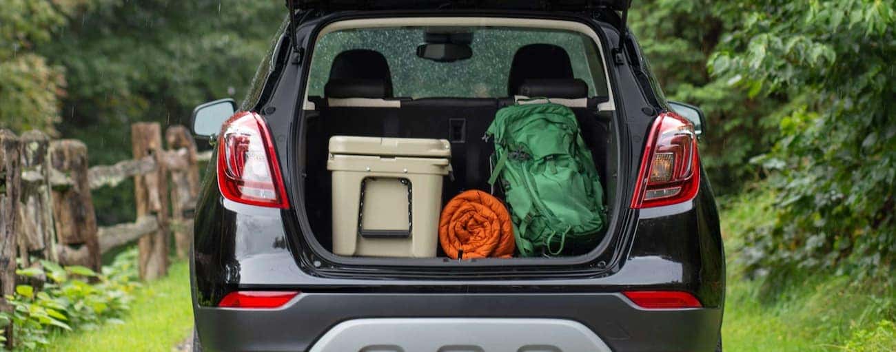 The trunk of a 2021 Buick Encore is shown open with cargo in the back.