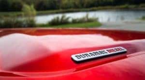 A closeup shows the Duramax Diesel badging on a red 2021 GMC Canyon SLT, a smaller 2021 GMC diesel truck.