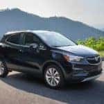 A black 2021 Buick Encore is parked in an empty lot with mountains in the background after leaving a Buick dealership in Atlanta.