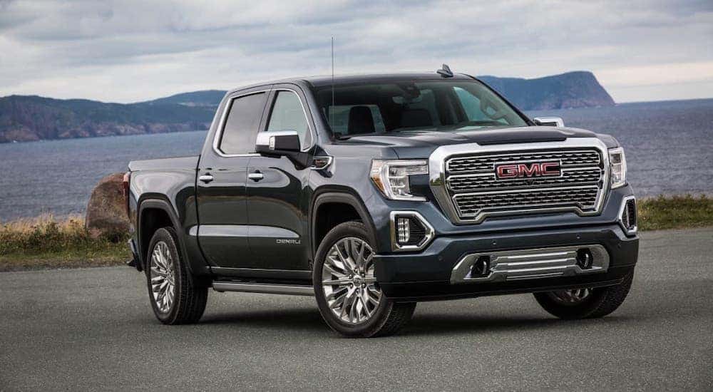 A black 2021 GMC Sierra 1500 Denali is parked in front of a body of water.