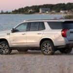 A white 2021 GMC Yukon AT4 is shown from the side parked on a beach.