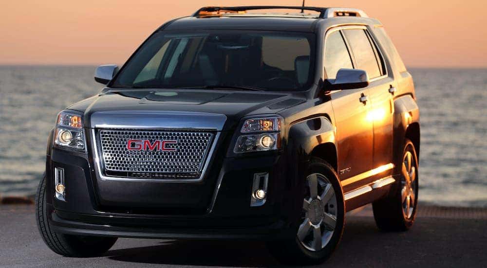 A black 2013 Terrain Denali is parked next to the ocean.