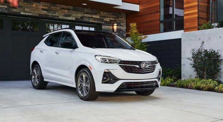 A white 2020 Buick Encore GX ST is shown parked in the driveway of a modern house.