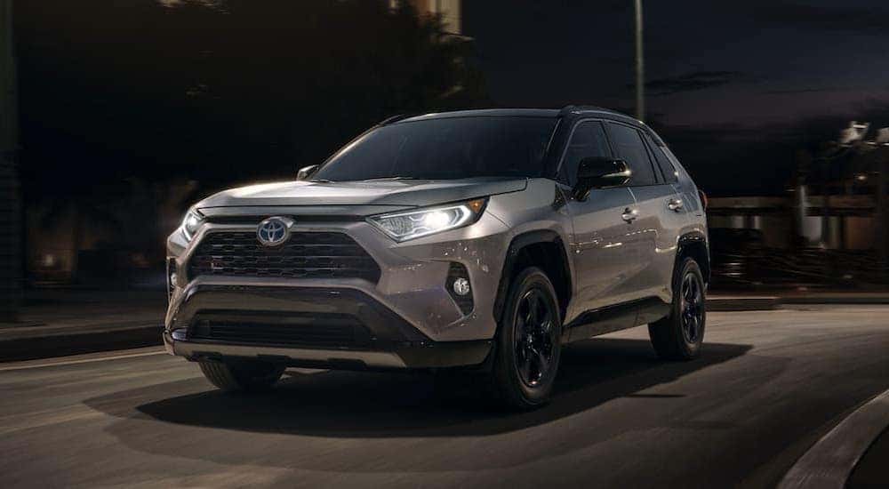 A silver 2020 Toyota RAV4 is shown driving at night.