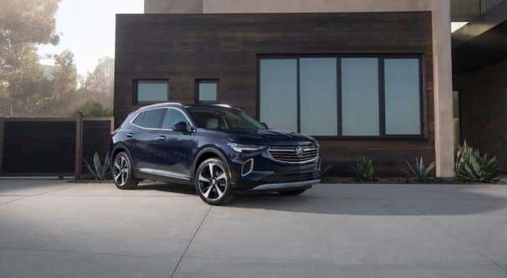 A blue 2022 Buick Envision is shown parked in front of a modern house.