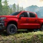 A red 2020 Chevy Silverado 1500 is shown from the side parked in the mountains.