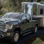 A grey 2022 GMC Sierra is shown towing a closed trailer after leaving an Atlanta truck dealer.