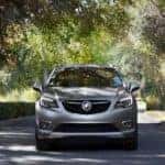 A grey 2020 Buick Envision is shown from the front driving on an open road after looking at a used Buick in Atlanta.