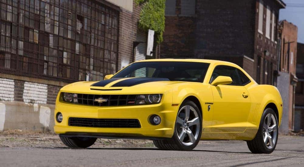 A yellow 2010 Chevy Camaro Transformers Edition is shown parked outside of a used Chevy dealership in Atlanta.