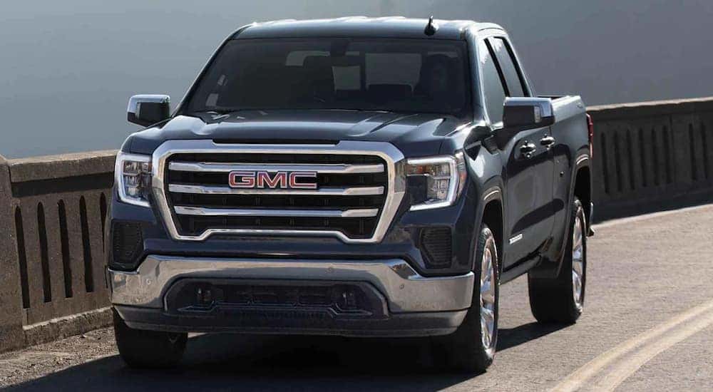 A black 2022 GMC Sierra Limited is shown driving over a bridge after leaving a Norcross GMC dealer.