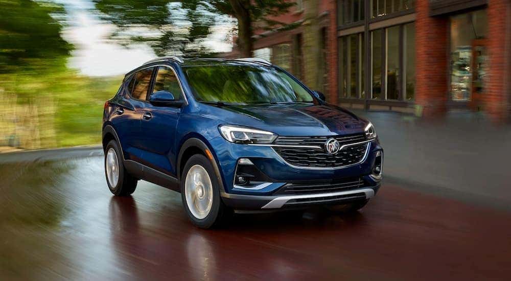 A blue 2020 Buick Encore GX is shown from the front driving on an open road after leaving a Certified Pre-Owned Buick dealer.