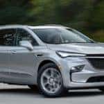A silver 2022 Buick Enclave is shown from the side driving on an open road after leaving a Norcross Buick dealer.