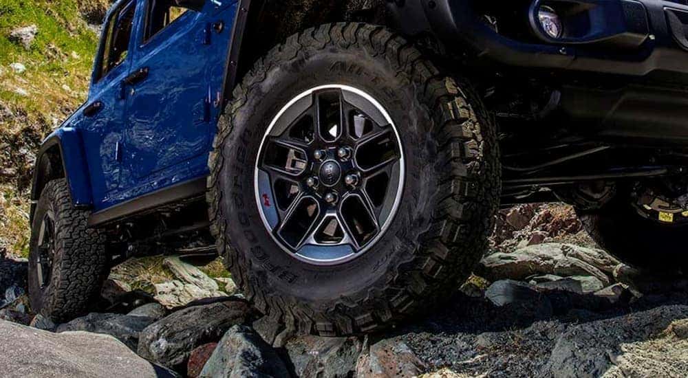 A close up of the tire on a blue 2019 Jeep Wrangler is shown after viewing used Jeep Wranglers for sale.