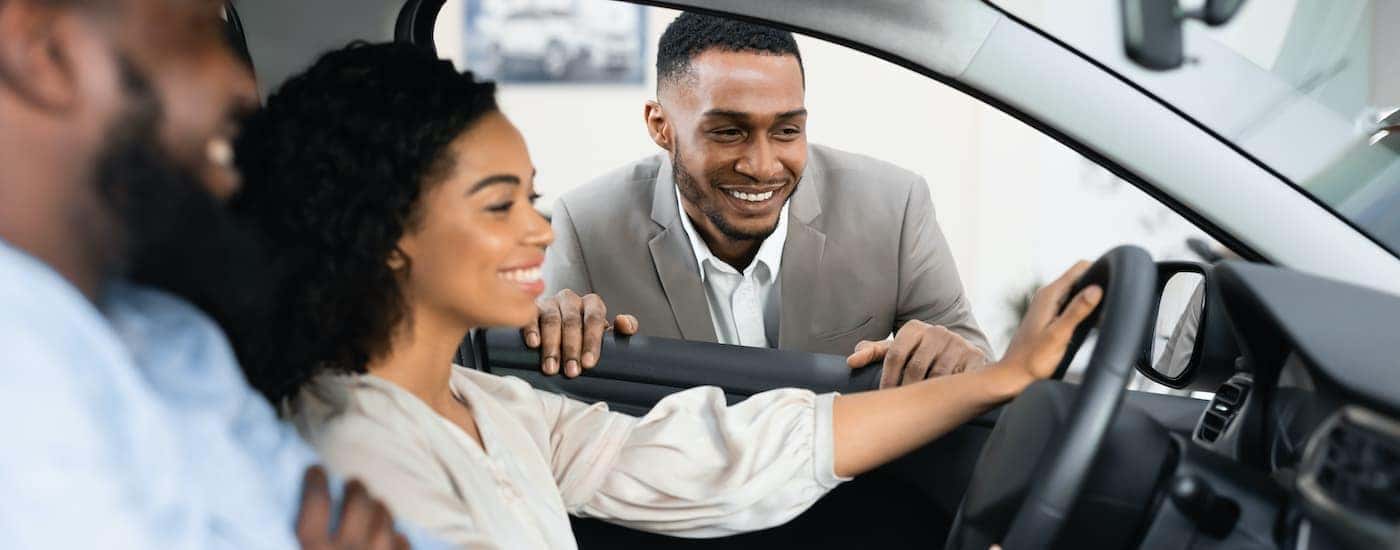 A couple is shown sitting in the front seat of a car after searching "Johns Creek Buick dealer."