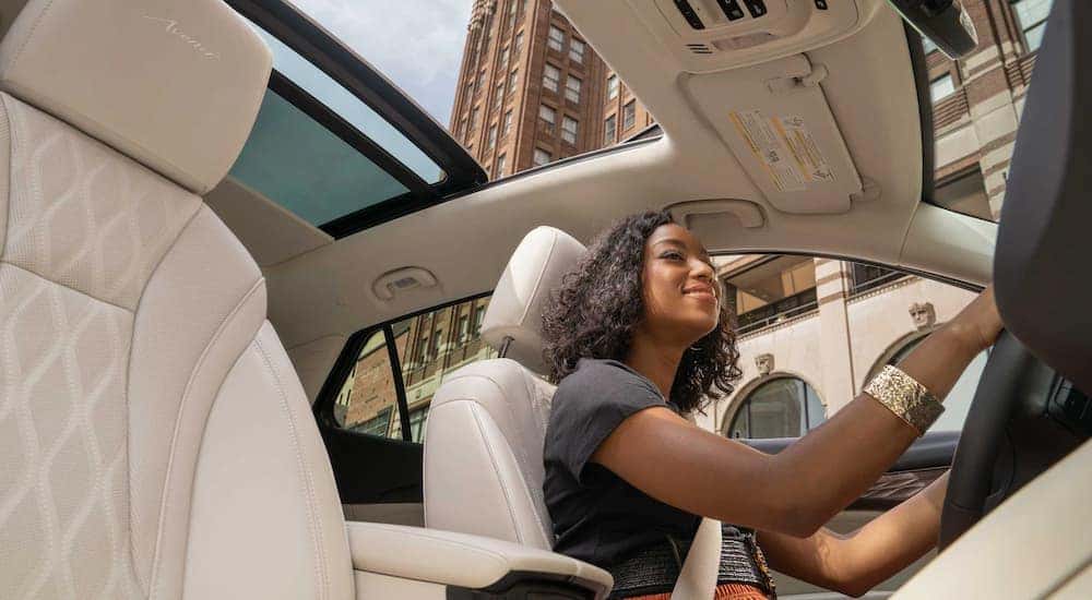 A woman is shown driving a 2022 Envision through a city.