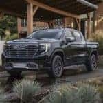 A grey 2022 GMC Sierra 1500 Denali Ultimate is shown from the front at an angle while parked in front of a house after leaving a Chamblee GMC dealership.