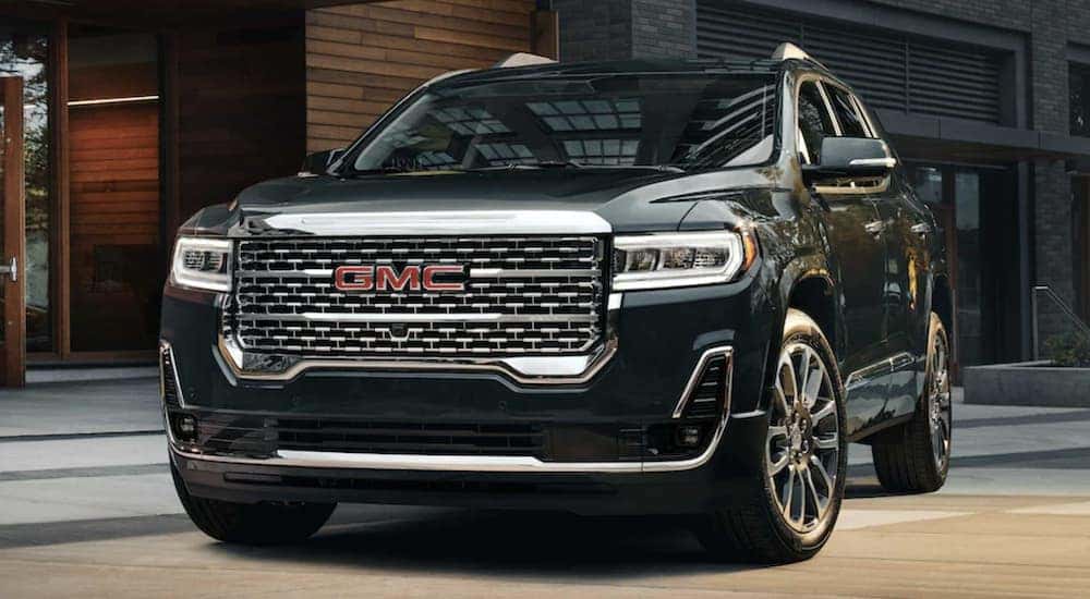 A black 2022 GMC Acadia is shown parked in front of a building.