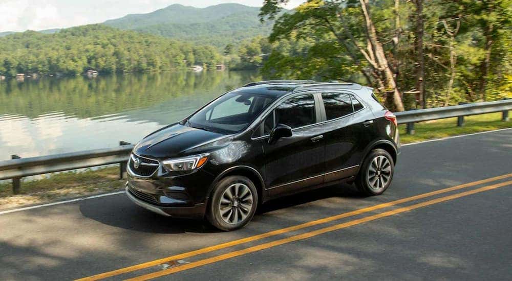 A black 2022 Buick Encore is shown from the front at an angle one a lakeside road.