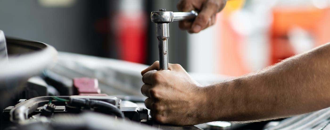 A mechanic is shown performing service repairs.