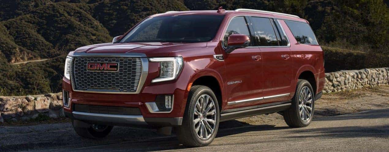 A red 2023 GMC Yukon Denali is shown from the side.