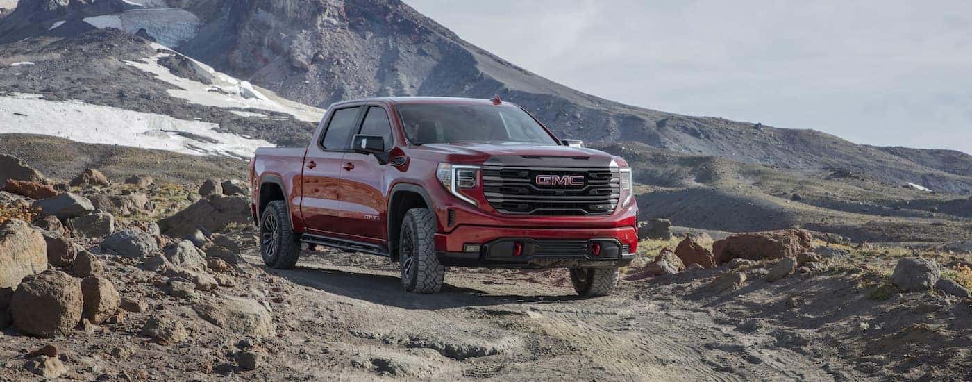 A red 2022 GMC Sierra 1500 AT4X is shown from the front at an angle in a mountainous area.