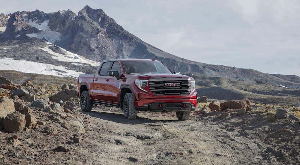 A red 2022 GMC Sierra 1500 AT4X is shown from the front at an angle in a mountainous area.