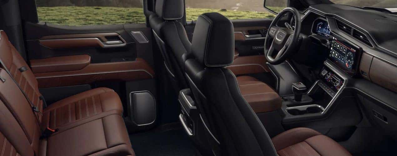The black and brown interior of a 2023 GMC Sierra 1500 shows two rows of seating.