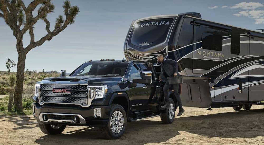 A black 2022 GMC Sierra 3500HD is shown towing a trailer.