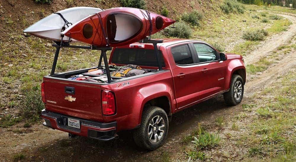 A red 2020 Chevy Colorado Z71 is shown from a rear angle on a grassy trail.