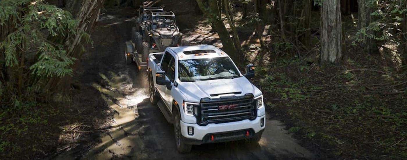 A white 2021 GMC Sierra 2500HD AT4 is shown from the front at a high angle.