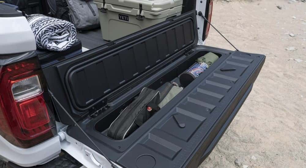 Bed storage is shown on a white 2023 GMC Canyon AT4.