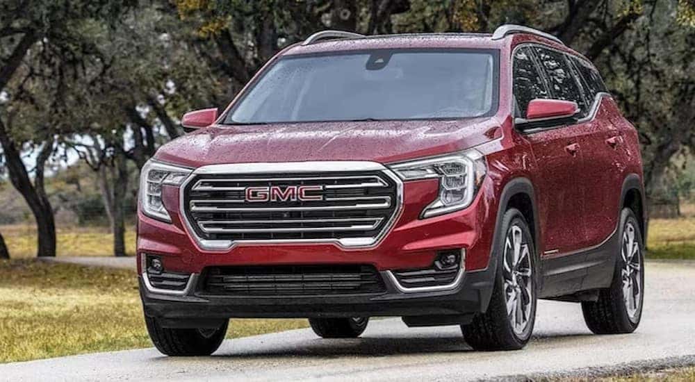 A red 2023 GMC Terrain for sale is shown parked on a road.