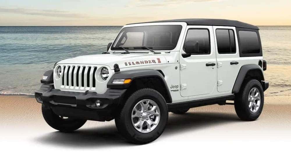 A popular used Jeep Wrangler for sale, a white 2021 Jeep Wrangler Islander, is shown parked near the ocean.