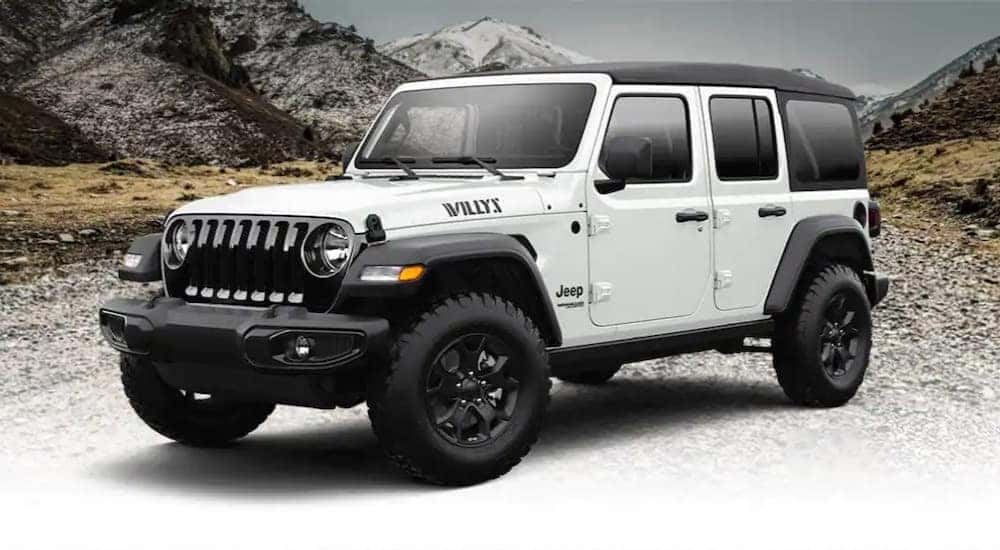 A 2022 Jeep Wrangler Willys Sport is shown parked on a rocky road.