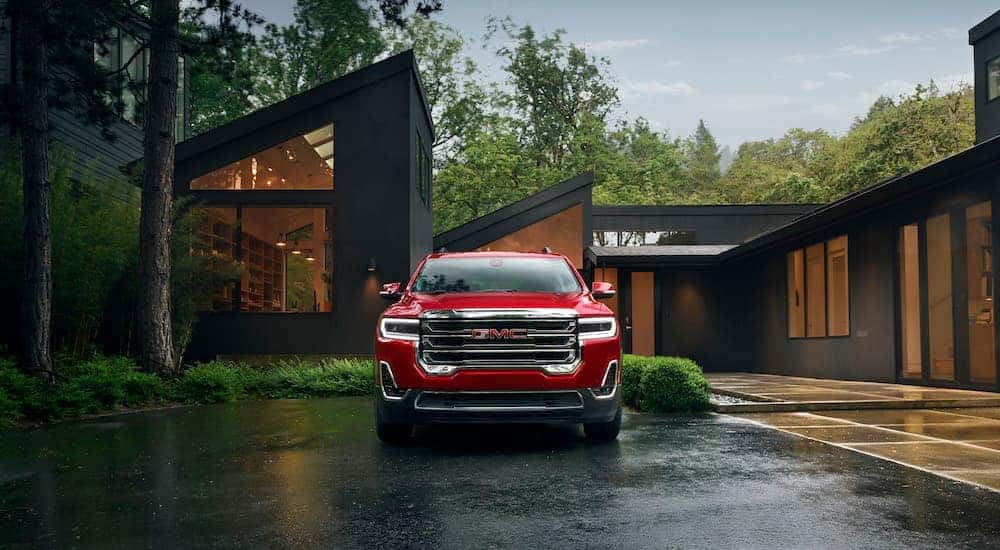 A red 2023 GMC Acadia SLT is shown from the front.