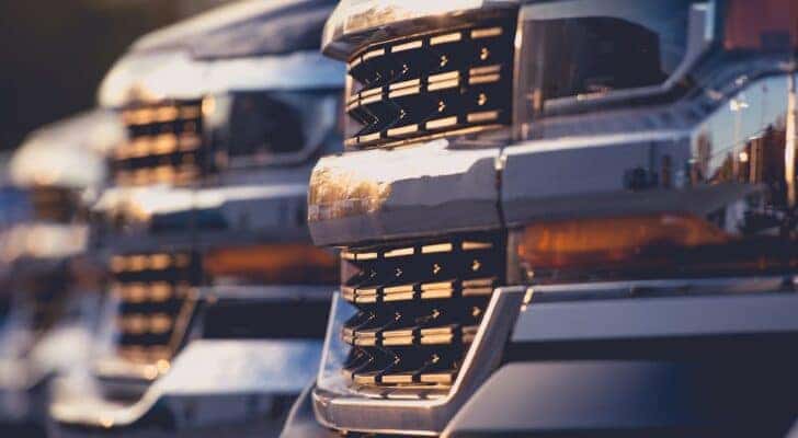 A row of used lifted trucks for sale near Atlanta is shown.