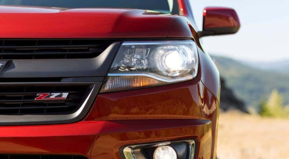 A close up shows the drive side headlight on a red 2015 Chevy Colorado Z71.