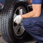 Service technician performing a tire rotation on a vehicle