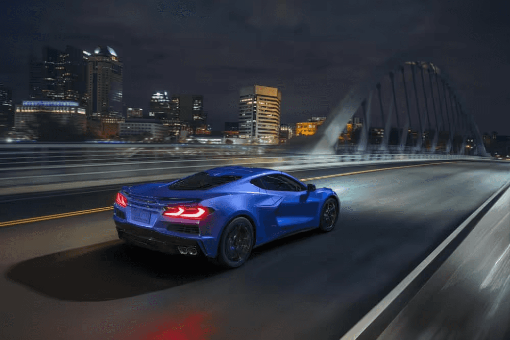 Blue car driving over bridge