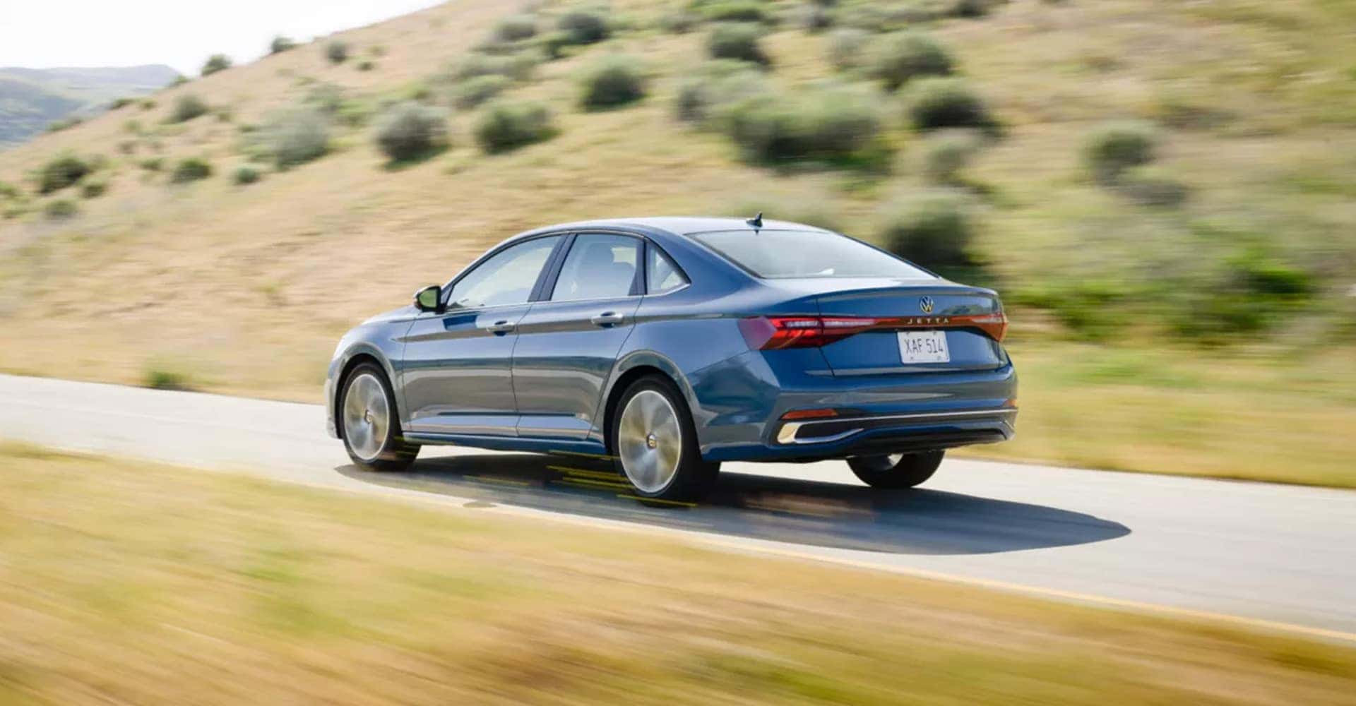 Back View of 2025 Volkswagen Jetta Driving Down Road