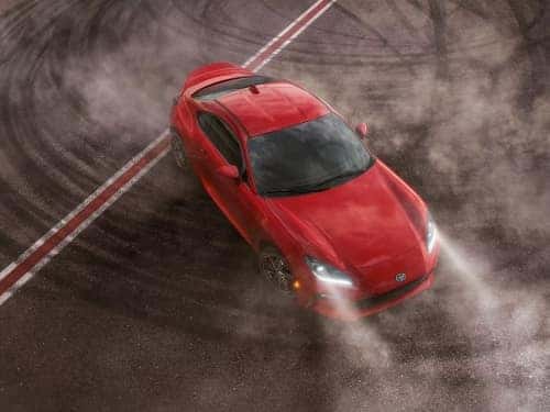 2024 Toyota GR86 overhead view of car doing donuts on black top