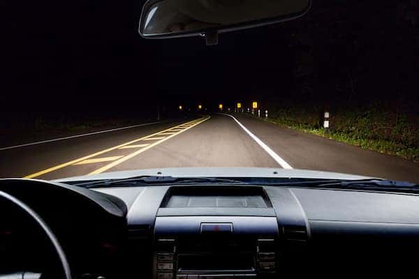 Car Driving Down Road At Night