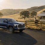 Toyota Tundra pulling a trailer on a country road next to a horse pasture