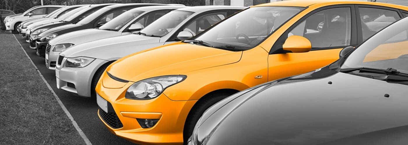 used car lot with orange highlighted vehicle