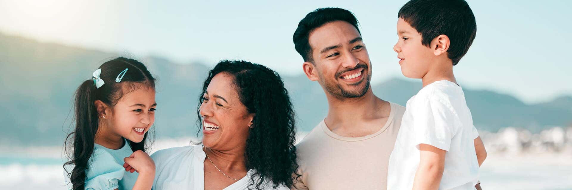 family of four smiling and laughing