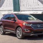 A used red Ford Edge from a local Ford dealer next to an old barn