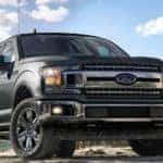 A dark grey 2019 Ford F-150 is parked at a job site. Check one out at a Ford dealership in Illinois.